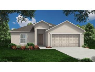 Charming single-story home featuring an attached two-car garage, manicured lawn, and inviting front entrance at 217 Harper Estates Cir, Lake Wales, FL 33859