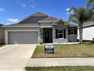 Charming single-Gathering home with stone accents, well-maintained landscaping, and a two-car garage at 414 Taft Dr, Davenport, FL 33837