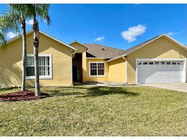 Charming single-story home featuring a well-manicured lawn and a two-car garage at 434 Acacia Tree Way, Kissimmee, FL 34758