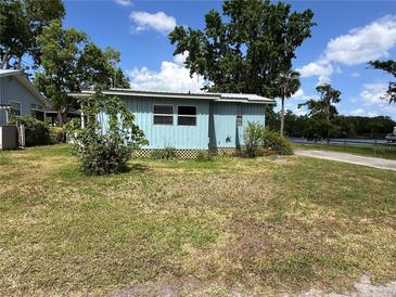 Charming single-story home with light blue siding and a well-maintained lawn at 55808 Nan Dr, Astor, FL 32102