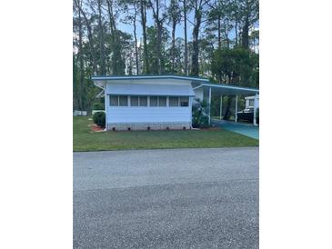 Charming single-story home featuring a carport and freshly landscaped yard at 103 Bougainvillea Dr, Leesburg, FL 34748