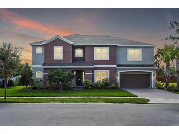 Beautiful two-story home boasts a two-car garage, manicured lawn and a combination of stucco and siding at 1447 Myrtle Oaks Trl, Oviedo, FL 32765