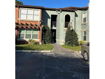 Two-story condo featuring stucco walls, large windows, and well-maintained landscaping at 5112 Conroy Rd # 17, Orlando, FL 32811