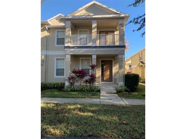 Charming two-story home with a balcony, front porch, and well-maintained landscaping at 7117 Red Lantern Dr # 7117, Harmony, FL 34773