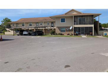 Beige two-story condo with covered parking and screened porch at 1640 Juno Trl # 101A, Astor, FL 32102