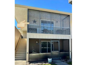 Condo featuring screened in patios with stairs leading to second floor unit at 1640 Juno Trl # 205B, Astor, FL 32102
