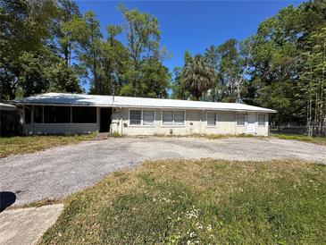 Charming single-story home with a metal roof and large front yard at 24047 Ermine Rd, Astor, FL 32102