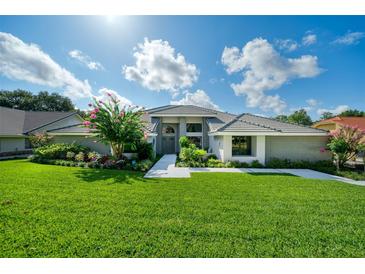 Beautiful one-story home with landscaped front yard, blooming tree, tile roof, and lovely curb appeal at 365 N Spaulding Cv, Lake Mary, FL 32746