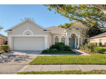 Charming one-story home with manicured lawn, lush landscaping, and a two-car garage at 9651 Old Marsh Ct, Orlando, FL 32832