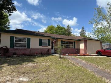 Charming single-story home with a brick facade, green shutters, and a well-maintained front yard at 120 Borada Rd, Sanford, FL 32773