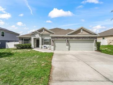 Charming single-story home featuring a three-car garage and inviting front lawn at 1936 Bell Creek Loop, Fruitland Park, FL 34731
