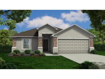Charming single-story home featuring stone accents, a well-manicured lawn, and an inviting front entrance at 378 Harper Estates Cir, Lake Wales, FL 33859