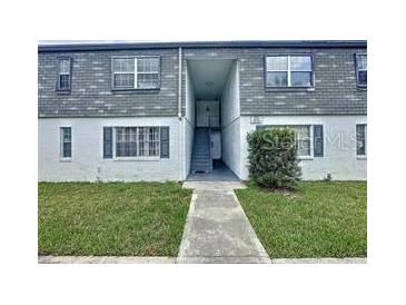 Inviting two-story condo with well-maintained landscaping and a gray shingle roof at 1000 S Semoran Blvd # 404, Winter Park, FL 32792