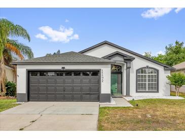 Charming single-story home features a gray roof, a two-car garage, and a well-maintained front yard at 11172 Pinewood Cove Ln, Orlando, FL 32817