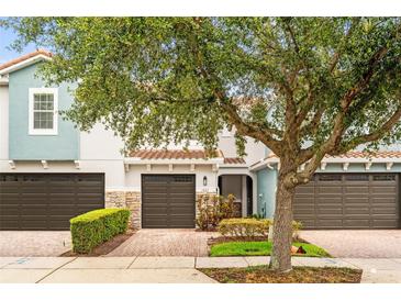 Charming townhouse featuring a brick driveway, attached garage, and well-maintained landscaping at 1880 Garden Sage Dr, Oviedo, FL 32765