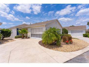 Charming one-story home with a well-manicured lawn, a driveway, and a pleasant exterior at 424 Valverda Dr, The Villages, FL 32162