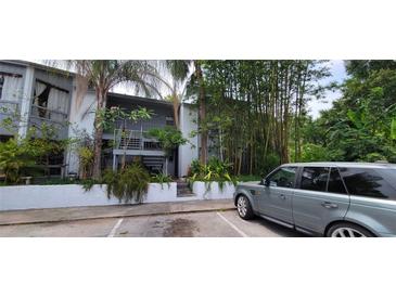 Charming condo exterior with gray facade, lush greenery, and a gray Range Rover in the parking area at 4300 Aqua Vista Dr # A, Orlando, FL 32839