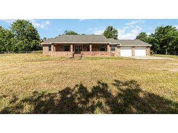 Charming single-story brick home with an attached two-car garage and a well-manicured lawn at 5155 Holopaw Rd, St Cloud, FL 34773