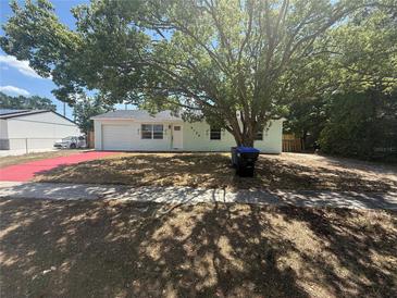 Charming single-story home featuring a well-manicured lawn and a red driveway at 6124 Fox Hunt Trl, Orlando, FL 32808