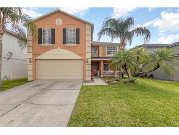 Charming two-story home featuring a large garage and well-maintained lawn with decorative palm trees at 709 Crystal Bay Ln, Orlando, FL 32828