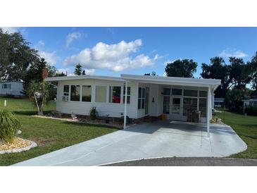 Attractive home with covered parking, pristine landscaping, and charming curb appeal at 102 Tangelo Cv, Leesburg, FL 34748