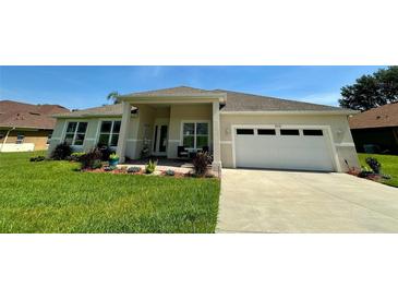 Charming single-story home featuring a well-manicured lawn and a two-car garage at 10640 Vista Del Sol Cir, Clermont, FL 34711