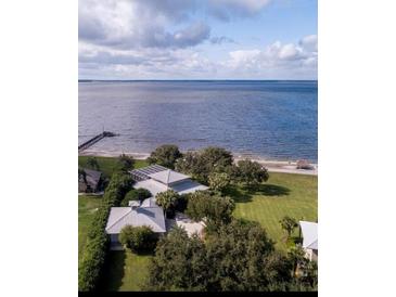 Stunning aerial view of the waterfront property with lush landscaping and private beach access at 12765 Se 143Rd Ave, Ocklawaha, FL 32179