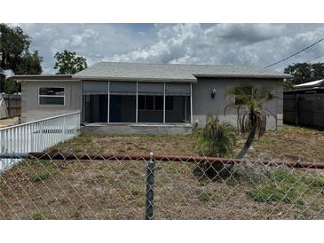 Modest single-story home with gray exterior, screen porch, and small palm tree at 2216 Weber St, Lakeland, FL 33801