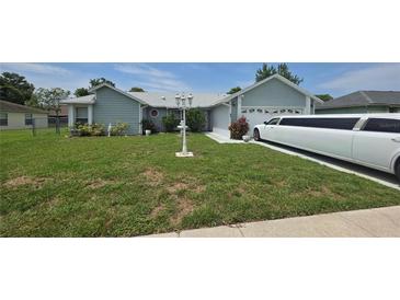 Charming single-story home with well-maintained lawn, landscape accents, and long limousine at 303 Silk Oak Dr, Kissimmee, FL 34743