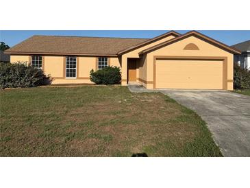 Charming single-story home with a well-manicured lawn and a two-car garage at 6608 Madeira Ave, Lakeland, FL 33811