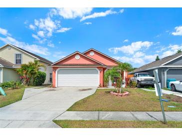 Charming single Gathering home with a well maintained lawn, flowering landscape, and a two car garage at 9668 Hollyhill Dr, Orlando, FL 32824