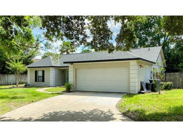 Charming single-story home featuring an attached two-car garage and a well-maintained front lawn with mature trees at 1011 Chance Cv, Oviedo, FL 32765