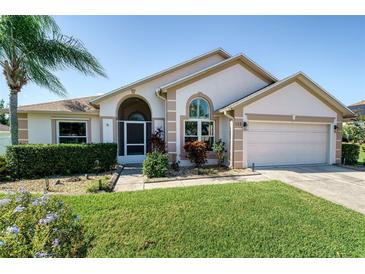 Charming single-story home featuring a well-manicured lawn and inviting front entrance at 115 Henue Ct, Davenport, FL 33896
