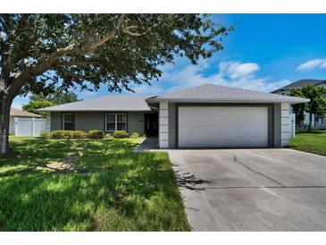 Charming single-story home with a well-maintained lawn, mature tree, and inviting curb appeal at 130 Evergreen Dr, Auburndale, FL 33823