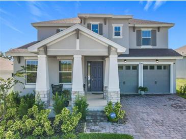 Charming two-story home boasts a manicured lawn and a two-car garage at 2044 Keystone Pass Blvd, Minneola, FL 34715