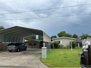 Charming single-story home with covered parking, lush lawn, and tasteful landscaping at 24505 Snail Rd, Astor, FL 32102