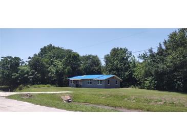 Charming home featuring a bright blue roof and neutral gray siding, nestled on a well-maintained lawn at 2822 S Dean Rd, Orlando, FL 32825