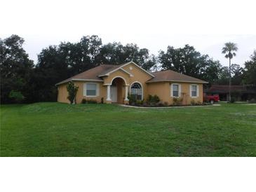 Charming single-story home with a well-manicured lawn, arched entry, and mature landscaping at 2913 Deerbrook Dr, Lakeland, FL 33811