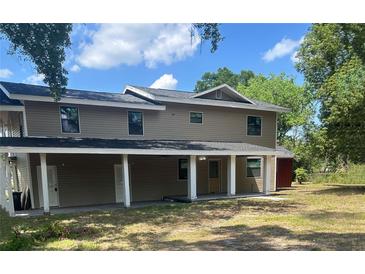 Two-story home featuring neutral siding, a covered front porch, and classic architectural design at 2921 Crutchfield W Rd, Lakeland, FL 33805