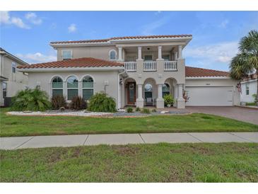 Stunning two-story home with a tile roof, columns, and a well-manicured lawn and garden at 3869 Shoreside Dr, Kissimmee, FL 34746