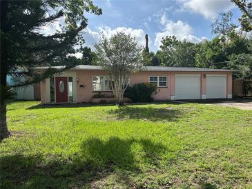 Charming single-story home with a well-manicured lawn and inviting red front door at 907 N Hyer Ave, Orlando, FL 32803