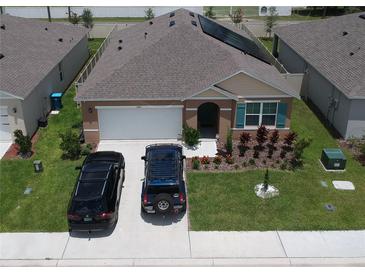 A charming single-Gathering home features solar panels, a two-car garage, and a beautifully landscaped front yard at 3041 Tobago Dr, Haines City, FL 33844
