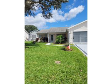 Charming single-story home with well-maintained lawn and landscaping, including an attached one-car garage at 527 San Pedro Dr, The Villages, FL 32159
