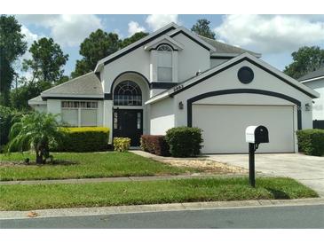 Two-story house with a white exterior, black accents, and a two-car garage at 2863 Picadilly Cir, Kissimmee, FL 34747