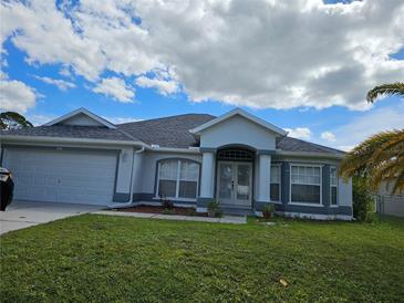 Charming single-story home with well-maintained lawn, blue accent paint, and attached two-car garage at 959 Nancy Ct, Kissimmee, FL 34759