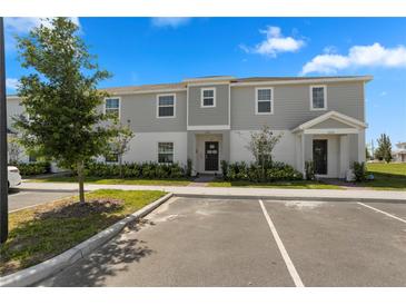 Two-story townhome with gray siding, landscaping, and a paved driveway at 1330 Blazing Star Ln, Davenport, FL 33837