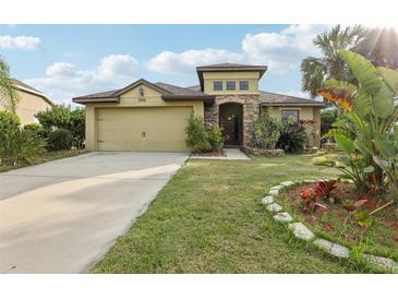 Charming single-Gathering home with a well-maintained lawn, stone accents, and a two-car garage at 2703 Gullane Ct, Kissimmee, FL 34746