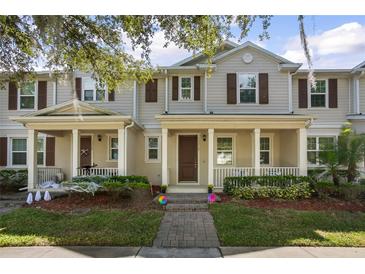 Charming townhome featuring a welcoming front porch and well-maintained landscaping at 13712 Summerport Village Pkwy, Windermere, FL 34786