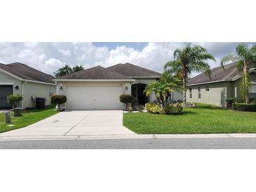 Exterior showcasing a well-maintained home with a manicured yard, lush landscaping and mature palm trees at 7139 Cedarcrest Blvd, Lakeland, FL 33810