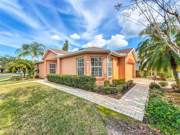 Charming single-story home featuring lush landscaping, a brick walkway, and a side entry garage at 167 Bell Tower Xing W, Poinciana, FL 34759